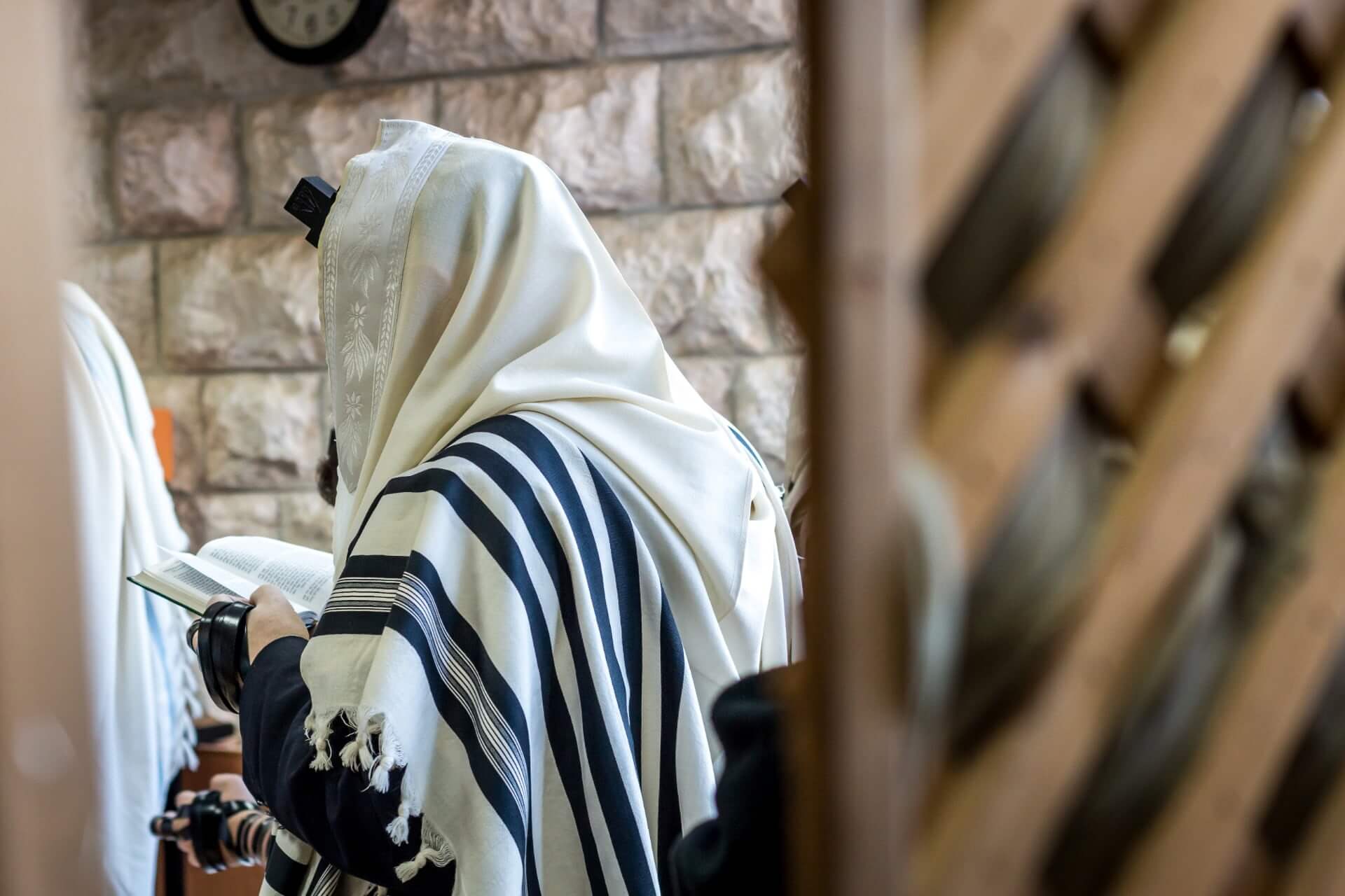 Homem vestindo talit lendo a Torah